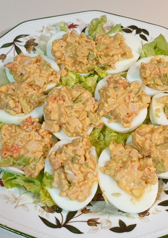 Una foto de Huevos rellenos de ensalada de gambas en cama de lechuga