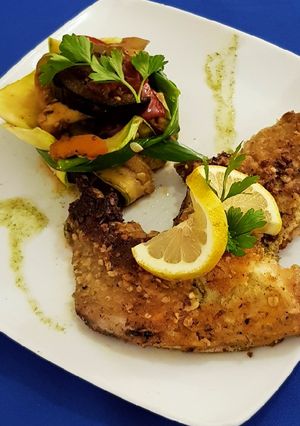 Una foto de Pescado de Río Crocante con Ratatouille Criollo en Canasta Zucch