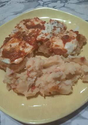 Una foto de Milanesas con queso y salsa acompañadas con puré de papas