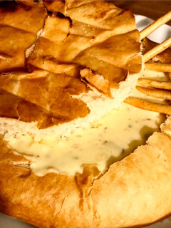 Una foto de Pan de campo con fondue de quesos, tocineta y ciboulette