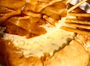 Una foto de Pan de campo con fondue de quesos, tocineta y ciboulette
