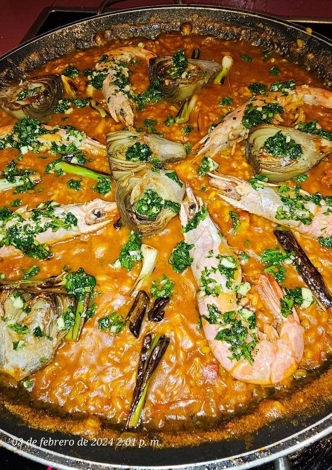 Una foto de Arroz Maty, con alcachofas confitadas, ajos tiernos, gambas langostineras y sepia