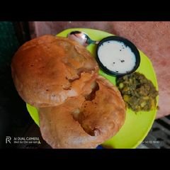 A picture of Aligarh kachori with aloo sabji and raita.