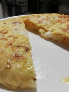 Una foto de Tortilla de patatas, cebolla caramelizada y queso de cabra