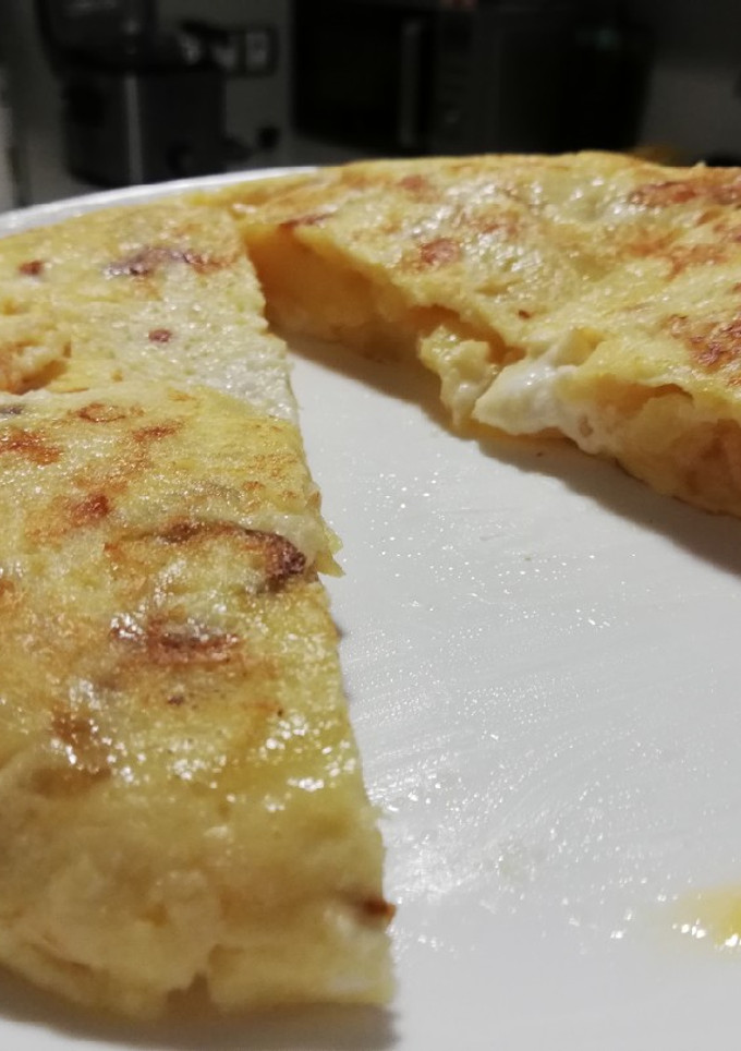 Una foto de Tortilla de patatas, cebolla caramelizada y queso de cabra
