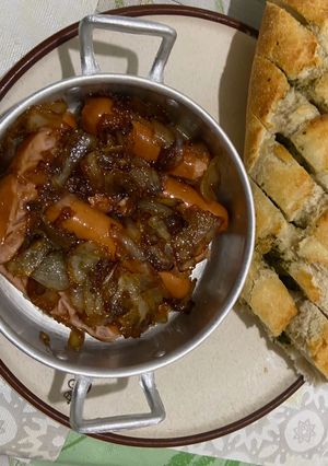 Una foto de Salchichas con cebolla caramelizada