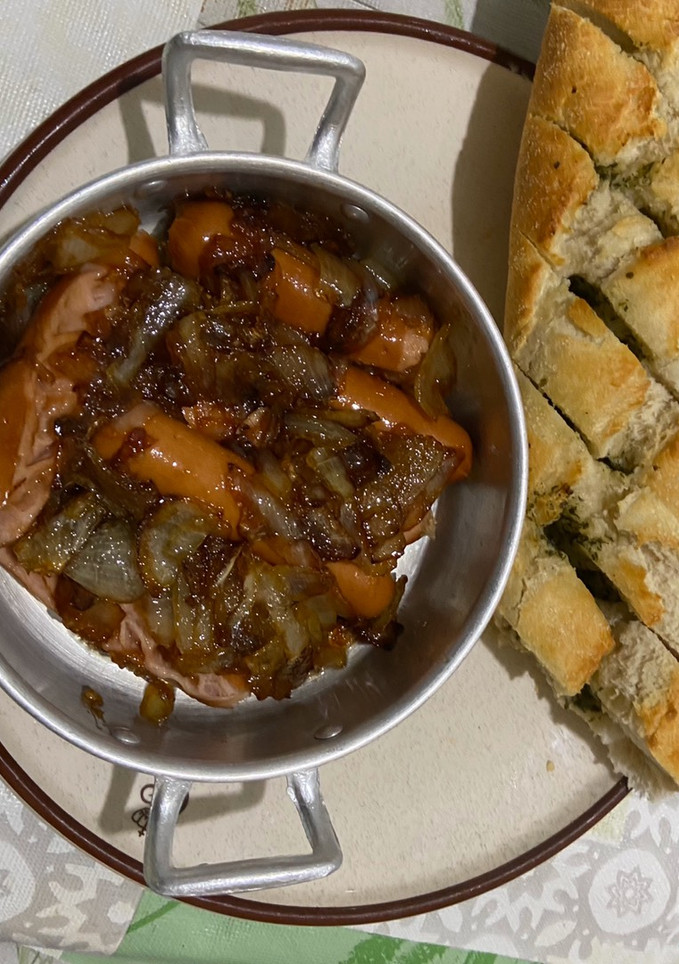 Una foto de Salchichas con cebolla caramelizada
