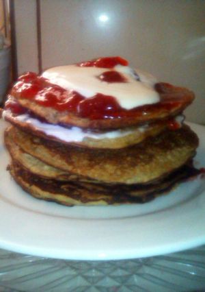 Una foto de Hot cakes, plátano, granola, mermelada de fresas y crema vegetal