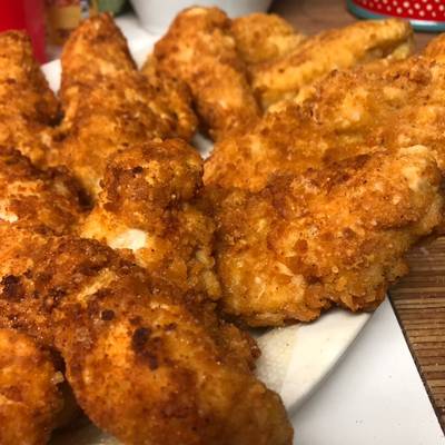 Chicken Strips Or Nuggets Being Deep-fried In A Cast-iron Frying