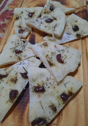 Una foto de Focaccia con olivas negras, tomillo y romero