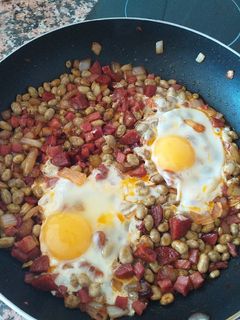 Una foto de Habitas con jamón, chorizo y huevo