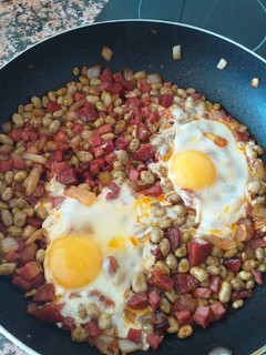 Una foto de Habitas con jamón, chorizo y huevo