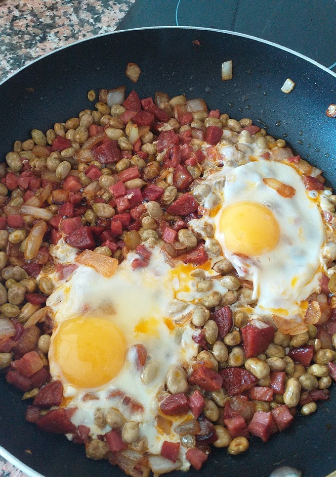 Una foto de Habitas con jamón, chorizo y huevo