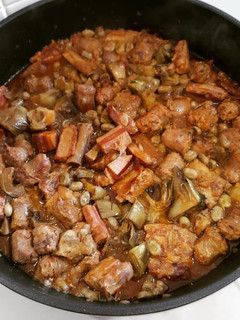 Una foto de Cazuela de costillas, panceta y butifarra con alcachofas