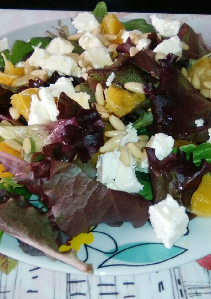 Una foto de Ensalada de naranja, queso feta y piñones