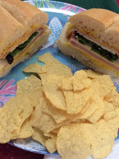 A picture of Ham, American cheese, lettuce, slices olives and mustard on Portuguese Bread 😋.