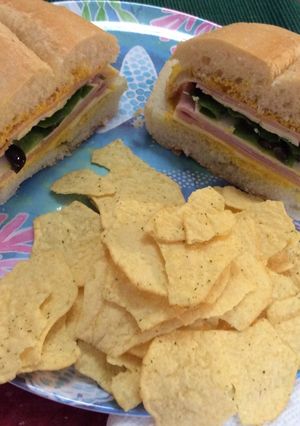 A picture of Ham, American cheese, lettuce, slices olives and mustard on Portuguese Bread 😋.
