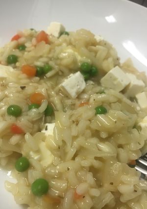 A picture of Vegetable risotto with cubed cheese.