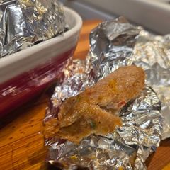A picture of Foil-wrapped kababs.