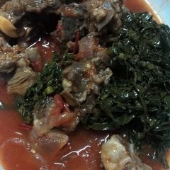 A picture of Mutton stew served saute kales.