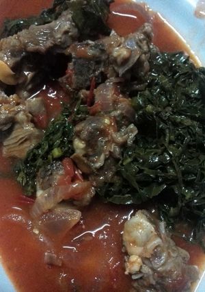 A picture of Mutton stew served saute kales.