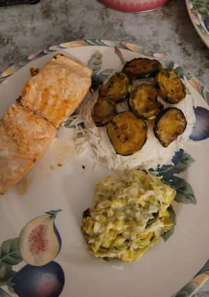 Une photo de Saumon accompagné de riz courgettes grillées et fondu de poireau