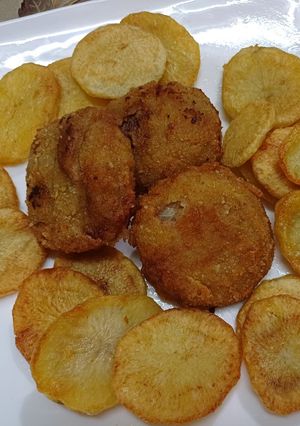 Una foto de Hamburguesas en aros de cebolla con papas al horno