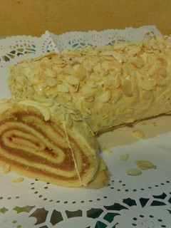 Una foto de Brazo de gitano relleno de turrón Jijona y revestido de chocolate blanco