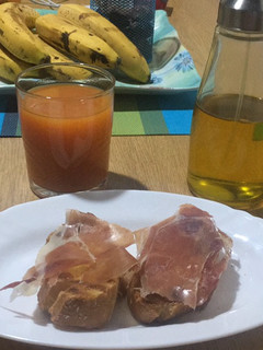 Una foto de Desayuno de diario de pan con tomate y jamón