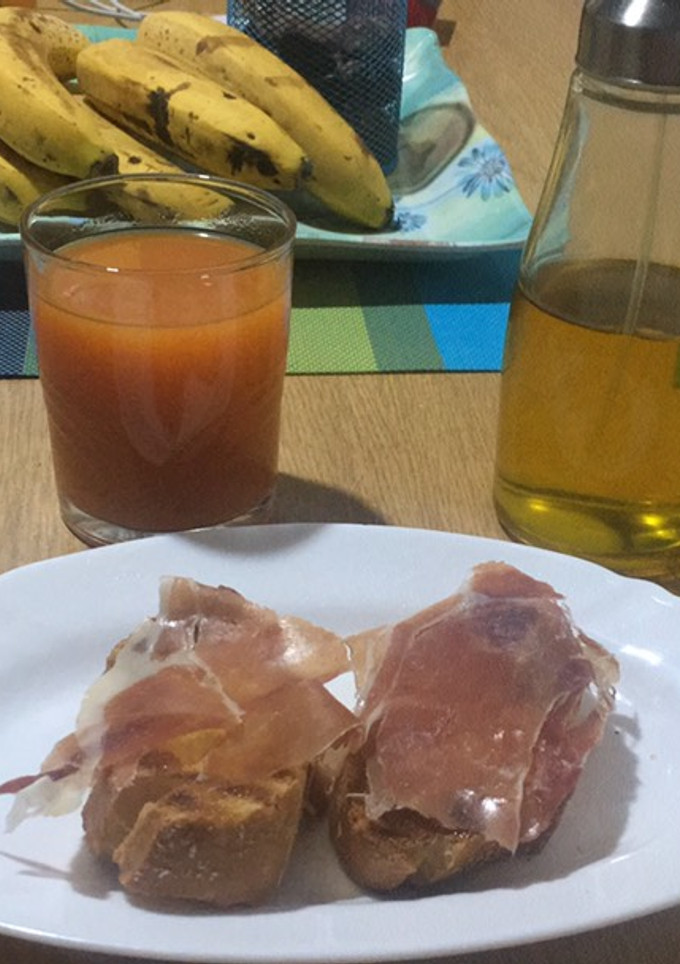 Una foto de Desayuno de diario de pan con tomate y jamón