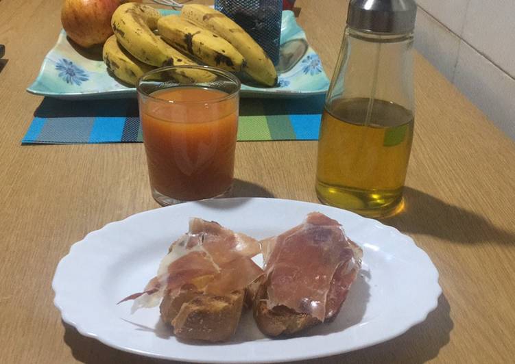 Desayuno de diario de pan con tomate y jamón