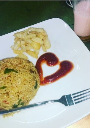 A picture of Fried rice and chips with ketchup.