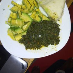 A picture of Ugali  with spinach and cabbage served with avocado.
