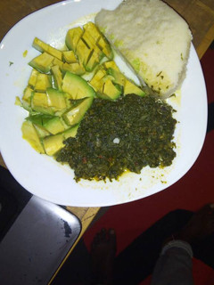 A picture of Ugali with spinach and cabbage served with avocado.