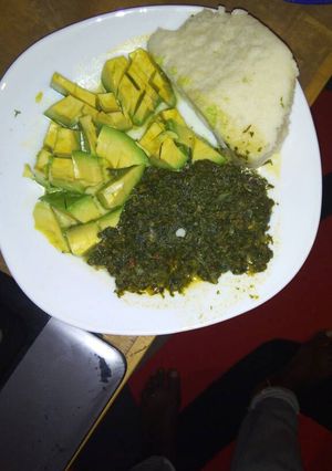 A picture of Ugali  with spinach and cabbage served with avocado.