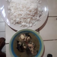 A picture of White rice with catfish and bitter leaf pepper soup.