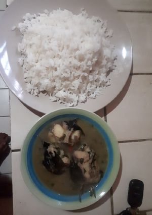 A picture of White rice with catfish and bitter leaf pepper soup.