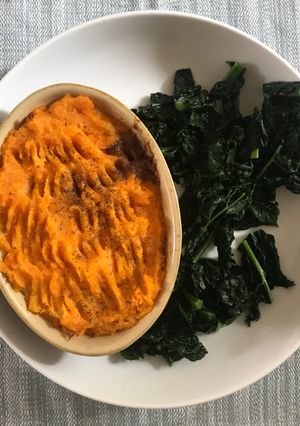 A picture of Cottage pie with vegetable mash top and black cabbage.
