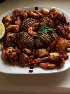 Una foto de Patatas al horno con calamares y gambas