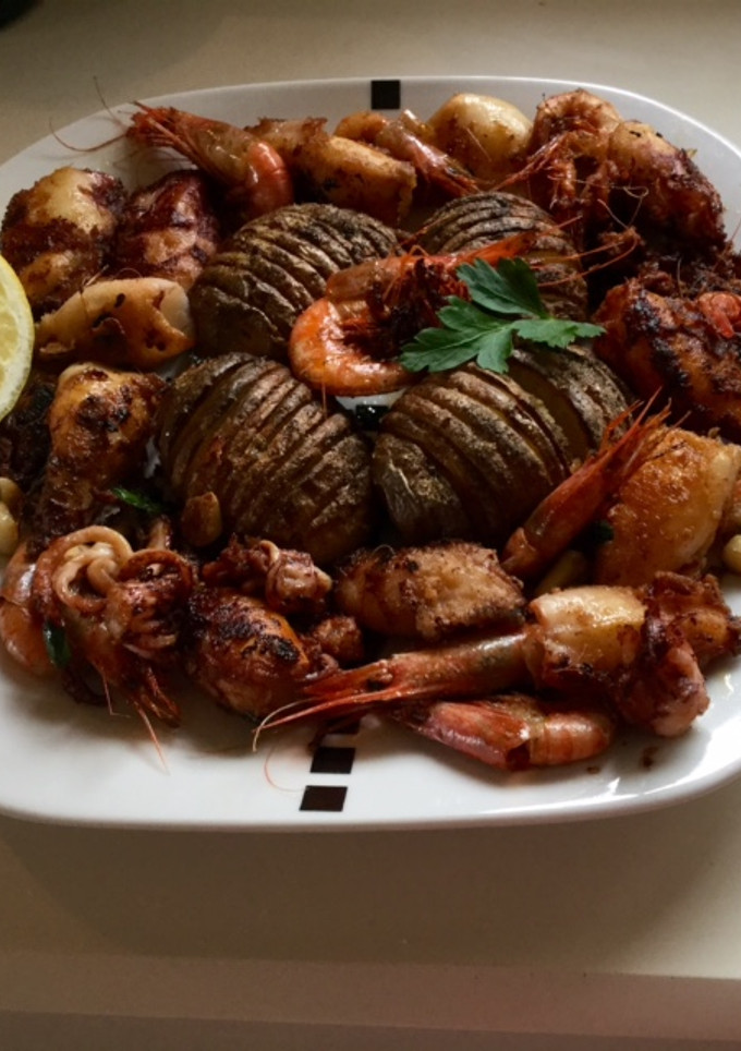 Una foto de Patatas al horno con calamares y gambas