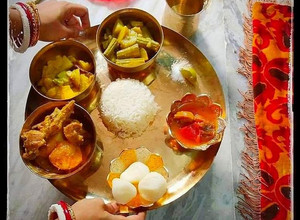 A picture of Bengali thali mutton kosa with plain rice, vegetable curry,alu posto,rasogolla and chutney.