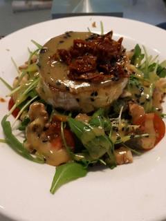 Una foto de Ensalada con cabra y crujiente de ibérico