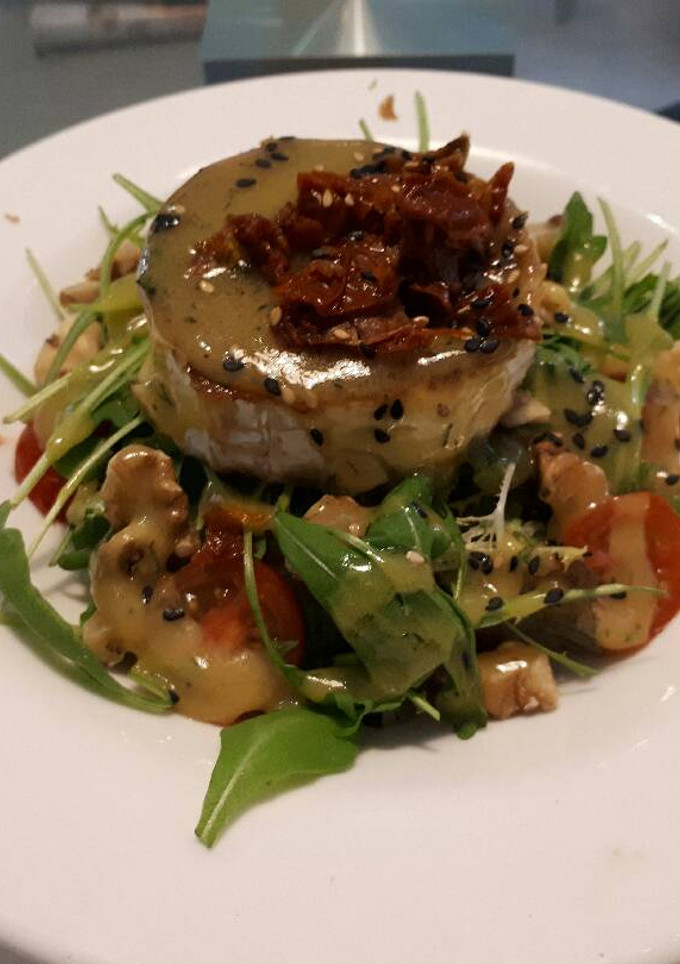 Una foto de Ensalada con cabra y crujiente de ibérico