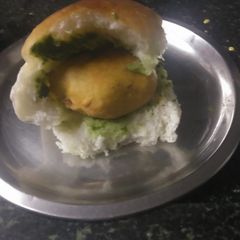A picture of Vadapav with green spicy chutney.