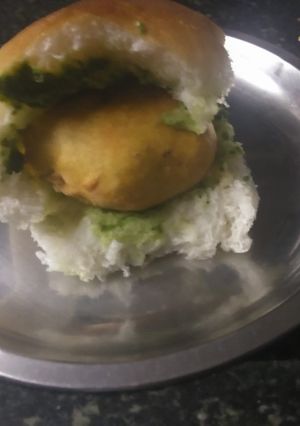A picture of Vadapav with green spicy chutney.