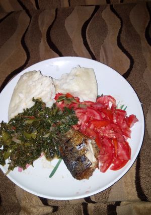 A picture of Ugali, Spinach and smoked fish.