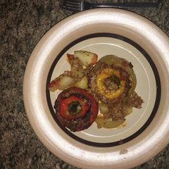 A picture of Stuffed peppers and tomato.