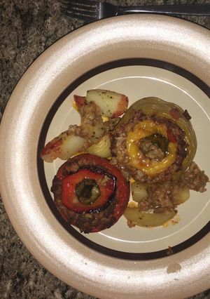 A picture of Stuffed peppers and tomato.