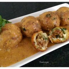 A picture of Mushroom koftas in tomato gravy.