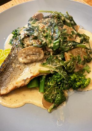 A picture of Pan fried Sea Bass with Wholegrain mustard, mushroom & spinach sauce. Finished with wild garlic.